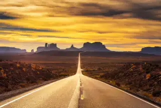A highway stretches through Monument Valley, Utah
